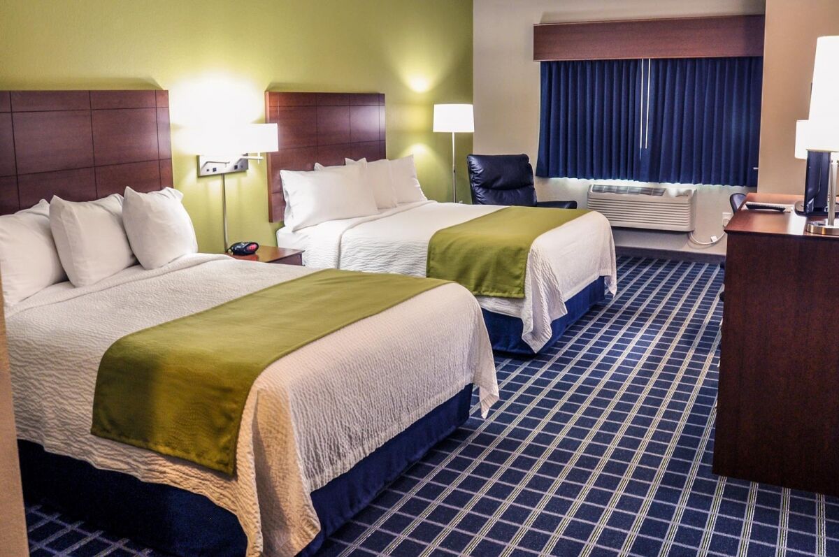Double queen room with two queen beds, work desk and warm wood furnishings