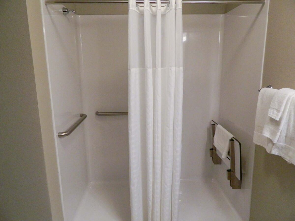 Accessible bathroom with roll-in shower, grab bars and fold-down seat